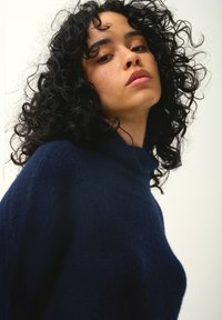 Marineblaue Woll-Turtleneck mit einer weichen, strukturierten Oberfläche und lockerer Passform. Mit hohem Kragen und leicht übergroßer Silhouette.