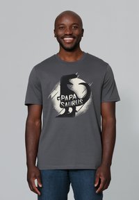 Graues Baumwoll-T-Shirt mit einem schwarzen Dinosaurier-Graphic und dem Text "PAPA SAURUS." Kurze Ärmel und runder Halsausschnitt.