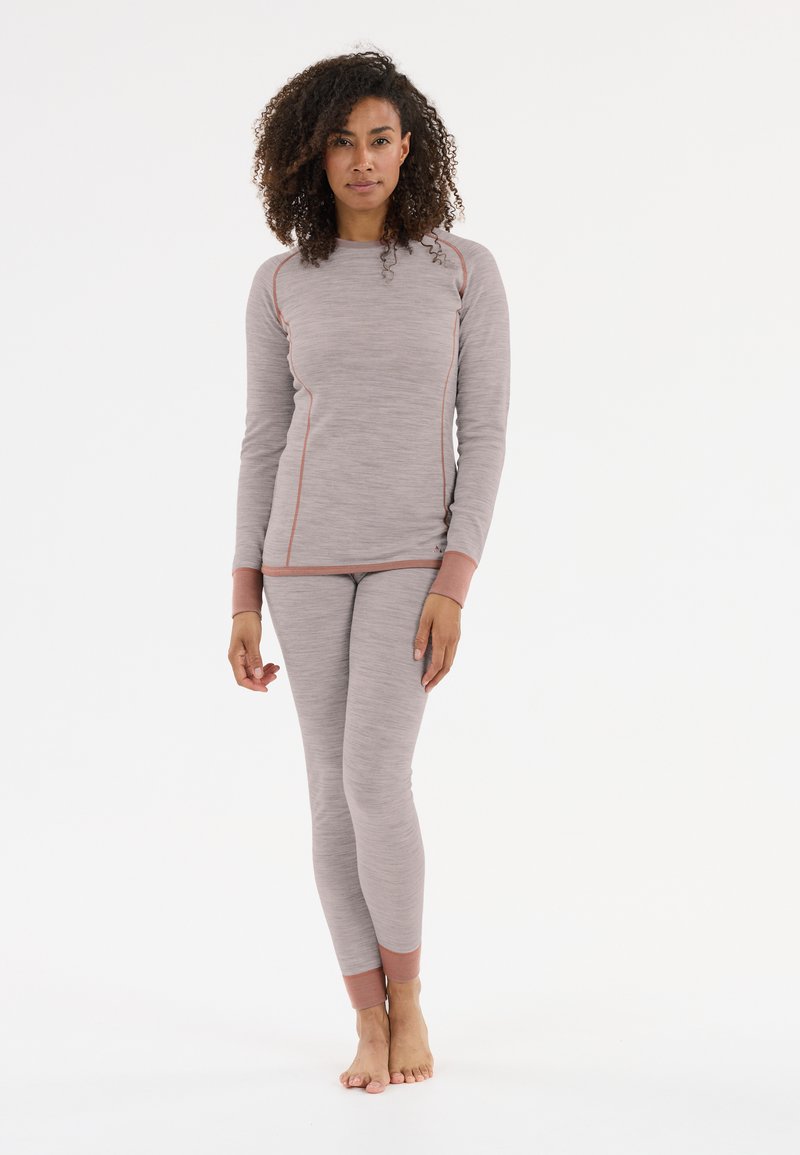Lichtgrijze long-sleeve top en bijpassende getailleerde broek, met textuurstof en contrasterende perzikkleurige accenten langs de naden en manchetten.