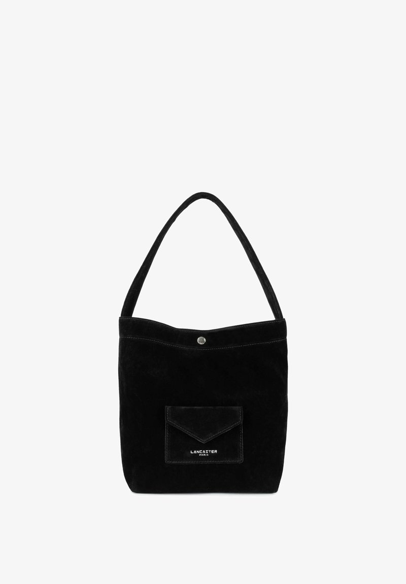 Sac fourre-tout en daim noir avec une bandoulière unique, une fermeture à bouton-pression, et une poche frontale équipée d'un rabat. Surface texturée avec un léger éclat.