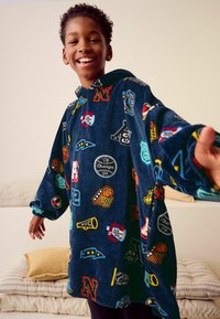 Marineblå fleece-hoodie med farverige sportsinspirerede patches, oversized design, lange ærmer og en frontlomme. Blød tekstur og afslappet pasform.