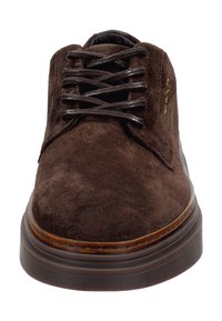Hnědé semišové šněrovací boty s kulatou špičkou, hladkým povrchem a hnědou gumovou podrážkou. Disponují jemným prošíváním a jednobarevným designem.