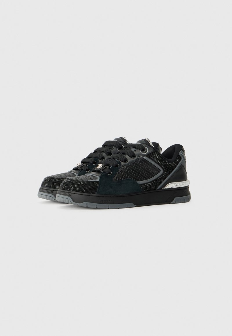 Des baskets noires avec un mélange de daim et de mesh texturé, présentant des accents argentés, des détails texturés et une semelle en caoutchouc durable.
