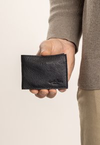 Schwarzes Lederportemonnaie mit strukturierter Oberfläche, gefalteter Bauweise und genähten Kanten. Mit geprägt Branding auf der Vorderseite.