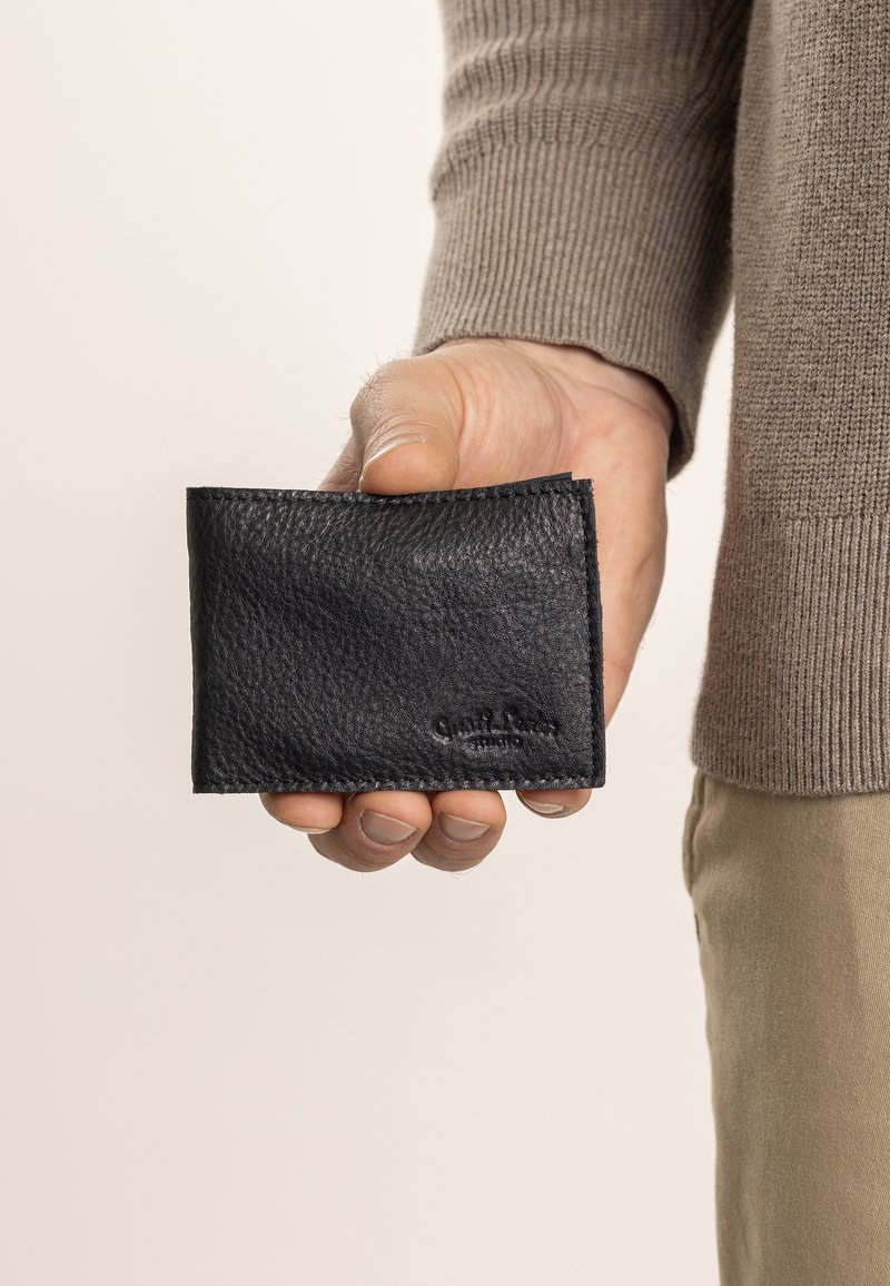 Schwarzes Lederportemonnaie mit strukturierter Oberfläche, gefalteter Bauweise und genähten Kanten. Mit geprägt Branding auf der Vorderseite.