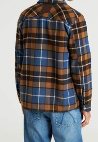 Koszula w kratę w kolorach niebieskim, brązowym i kremowym, z zapięciem na guziki, flanelową fakturą oraz detalem na plecach z brązowymi skórzanymi akcentami.