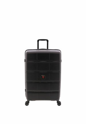 Valise rigide noire avec poignée télescopique déployée et quatre roues pivotantes, debout sur un fond blanc.