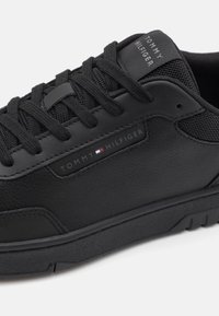 Czarne sneakersy z gładką skórzaną cholewką, teksturowanymi akcentami z siateczki oraz markowym logo z boku. Gumowa podeszwa z detalami zapewniającymi przyczepność.