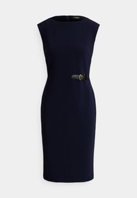 Tumši zila, pie ceļgala garuma, bez piedurknēm kleita ar piegulošu siluetu un melnu jostu ar zelta sprādzi viduklī.