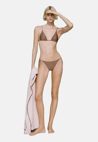 Ensemble bikini marron comprenant un haut triangulaire et un bas taille haute, avec un mannequin tenant une serviette rose clair. Design simple et épuré.