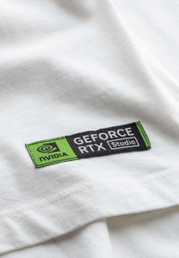 Witte katoenen t-shirt met een zwart en groen geborduurd NVIDIA GeForce RTX Studio logo patch. Soepele textuur en eenvoudig ontwerp.