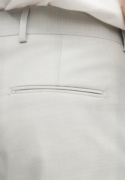 Ανοιχτό γκρι παντελόνι με υφή υφάσματος, διαθέτει μια μονή πίσω τσέπη με λεπτό άνοιγμα και θηλιά ζώνης πάνω από τη μέση.