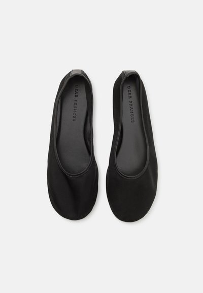 Chaussures plates noires en matériau lisse, avec un design à bout arrondi et des bords élastiqués pour un ajustement parfait. L'intérieur présente un logo en relief.