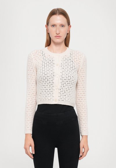 Cardigan en tricot rose clair, court, avec un motif ajouré texturé, un col rond et une fermeture à boutons sur le devant. Manches longues.