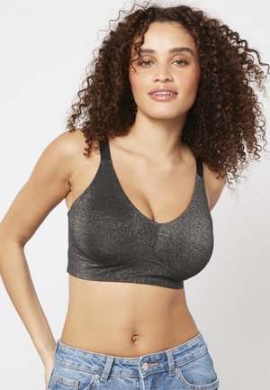 Bralette nera e luccicante con scollatura a V profonda e spalline larghe, caratterizzata da una texture liscia e un fit corto, abbinata a pantaloncini in denim.
