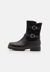 Botines negros de piel y ante con correas de doble hebilla, acabado texturizado y suela de goma gruesa. Forro de piel de borrego suave en la parte superior.