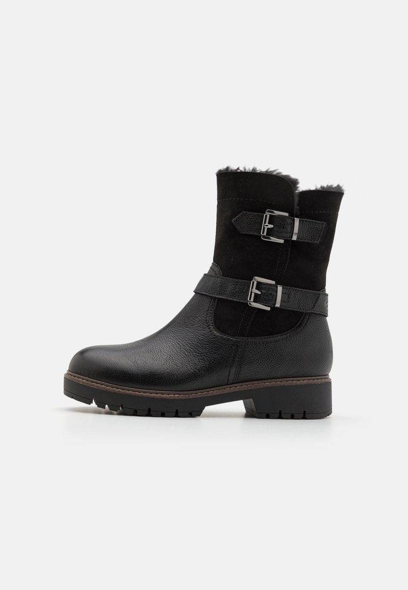 Botines negros de piel y ante con correas de doble hebilla, acabado texturizado y suela de goma gruesa. Forro de piel de borrego suave en la parte superior.