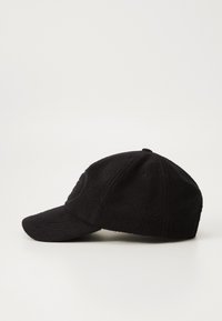 Black fleece cap with a curved brim, featuring textured fabric, and a subtle embossed logo. Designed for casual wear.