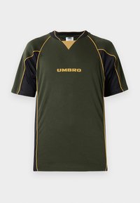 Tamsiai žalia ir juoda trumpomis rankovėmis sportinė marškinėlių, su garstyčių geltonos spalvos apdaila ir „UMBRO“ logotipu, esantį viduryje krūtinės.