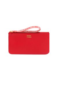 Rode leren pouch met een gladde textuur, een ritssluiting en een decoratieve polsband met de merknaam in het wit. Gouden logo aan de voorkant.