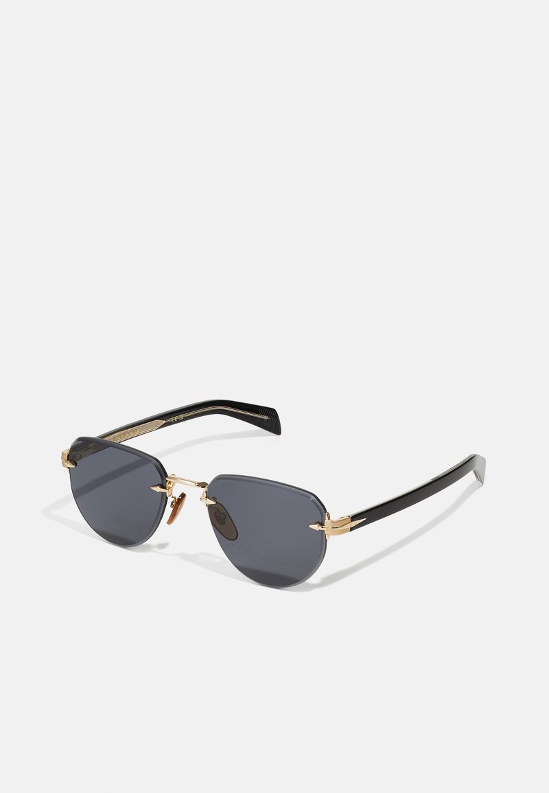 Ochelari de soare negri și gri cu o formă geometrică a lentilelor, accente metalice aurii și brațe din plastic negru cu un model subtil.