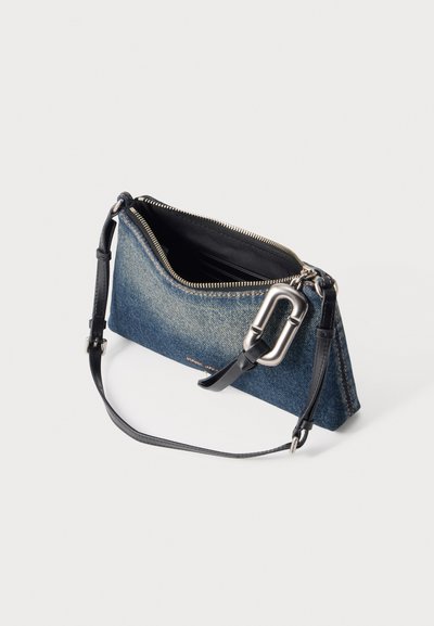 Petit sac à bandoulière en denim bleu avec sangle en cuir noir et boucle argentée, fermeture éclair ouverte pour montrer l'intérieur noir avec des emplacements pour cartes.