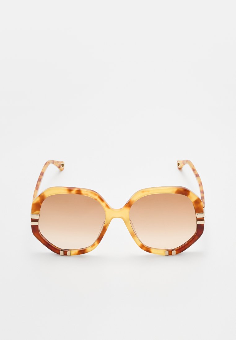 Braune Schildpatt-oversized Sonnenbrille mit Verlaufslinsen, die goldfarbene gestreifte Akzente an den Bügeln aufweist. Quadratförmiges Rahmendesign.