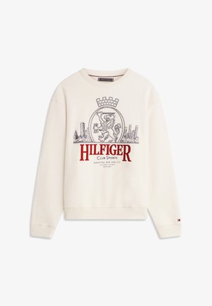 Krem pulover s grbom leva, mestnim obzorjem in besedilom »Hilfiger Club Sports Manhattan New York City« na sprednji strani.