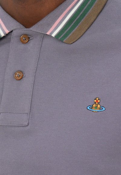 Polo gris con un tejido texturizado, que presenta un botón marrón y un cuello a rayas en verde, rosa y crema. Incluye un pequeño logo bordado.