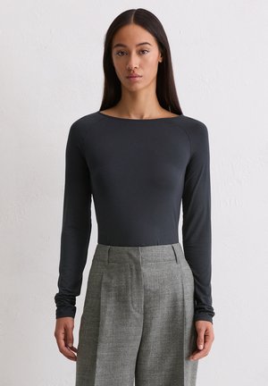 Langsleeve, donkergrijze body met een brede halslijn. De stof lijkt glad en rekbaar, gecombineerd met lichtgrijze hoge taillebroek.