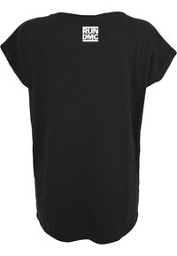 Svart bomulls t-shirt med lös passform, med en klassisk rund halsringning och korta ärmar. Vitt RUN DMC-logotyp tryckt på den övre delen av ryggen.