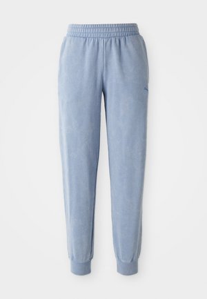 Blå sweatpants lavet af blødt stof med elastisk talje og manchetter; har en subtil tekstur og et lille logo på den ene side.