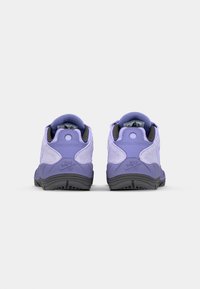 Sneaker Nike viola con tomaia texturizzata, collo imbottito, suola in gomma nera e logo in rilievo sul tallone.
