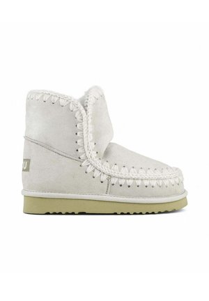 Stivaletto alla caviglia in suede grigio chiaro con cuciture bianche, suola flessibile, punta arrotondata e dettaglio con risvolto. Branding sottile sul lato.