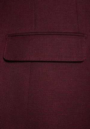 Bordowy materiał o teksturowanym splocie, z prostokątną klapką kieszeni przyszytą z jednej strony, o płaskiej i gładkiej powierzchni.