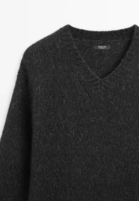 Dunkelgrauer Strickpullover mit V-Ausschnitt. Merkmale einen strukturierten Stoff mit dichter Webung und geripptem Kragen. Markenetikett ist innen sichtbar.