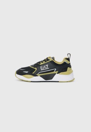 Black and olive green sneaker with mesh and synthetic materials, featuring a rounded toe, textured accents, and a white midsole.