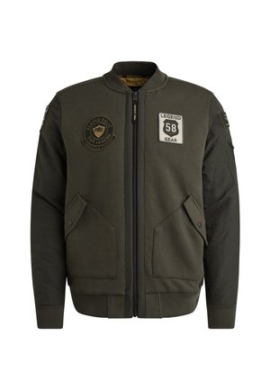Maslinasto zelena bomber jakna s teksturiranim materijalom, zatvaranje na zip, dva bočna džepa i izvezene zakrpe na prsima i rukavu.