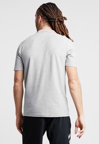 Grå t-shirt med korte ærmer lavet af bomuld, med en rund halsudskæring og glat tekstur. Minimalistisk design uden synlige mønstre.