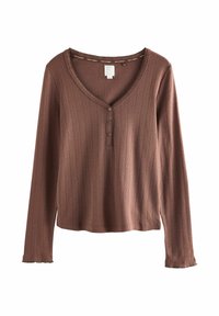 Maglia a maniche lunghe di colore rosa pallido, con texture a coste, scollatura a V e tre bottoni sul davanti. Tessuto morbido con dettaglio a orlo sfrangiato.