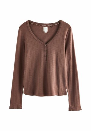 Langærmet bluse i en støvet rosa farve, ribbet tekstur, V-halsudskæring, og tre knapper foran. Blødt stof med frynsede kantdetaljer.