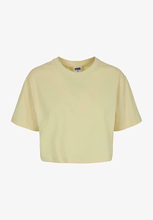 Trumpas rankovėmis, apkirptas marškinėliai šviesiai geltonos spalvos medvilnės, su apvalia iškirpte; turi minkštą tekstūrą ir laisvą, kvadratinę formą.