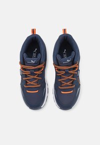 Marineblaue Sportschuhe mit orangefarbenen Akzenten, strukturiertem Stoff, gemusterten Schnürsenkeln und weißen Sohlen. Mit einem Zugband an der Ferse.