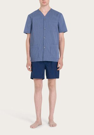 Camicia a maniche corte con bottoni, in fantasia a righe blu e bianche, scollo a V e due tasche frontali, abbinata a pantaloni corti blu navy.