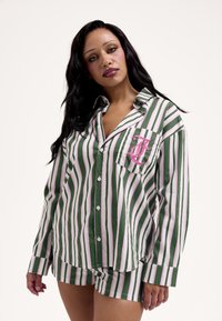 Zöld-fehér csíkos pizsamaszett rózsaszín részletekkel. Gombos felső és hozzáillő rövidnadrág. Hímzett részlettel ellátott zseb.