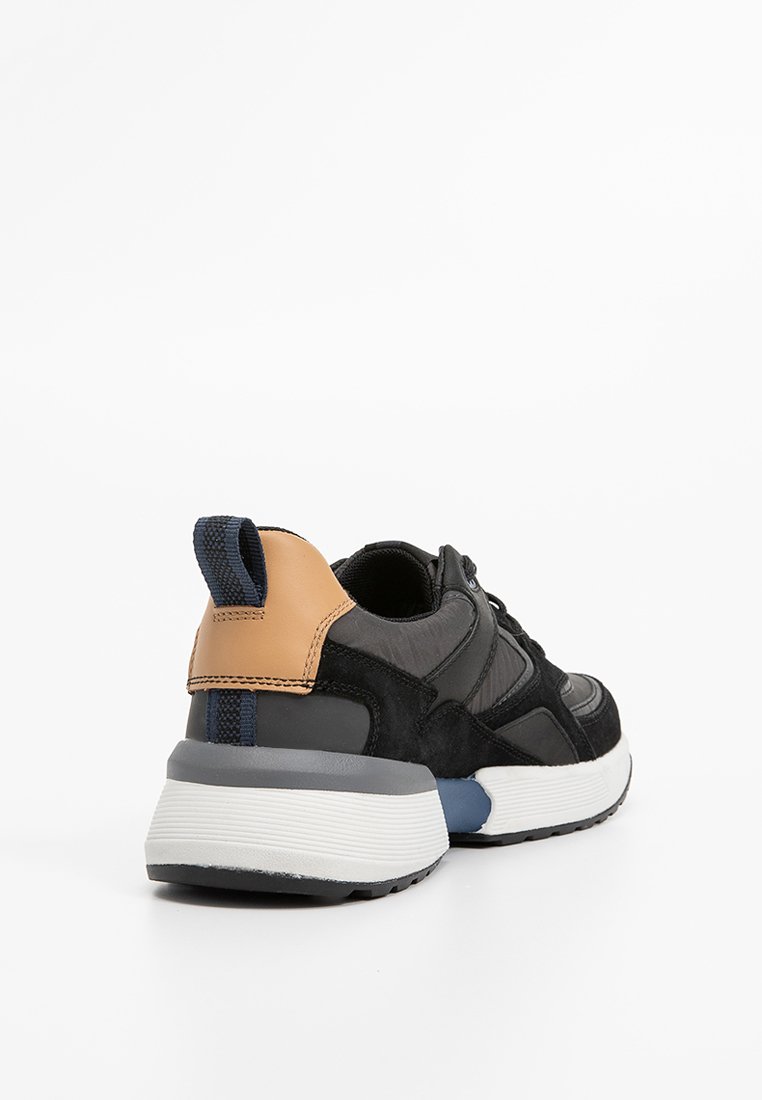 Schwarze Wildleder- und Mesh-Sneaker mit einem braunen Lederfersenstreifen, grauem Mittelsohlenbereich und blauen Akzenten, die ein strukturiertes Finish und ein robustes Design aufweisen.