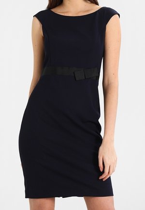 Robe ajustée bleu marine avec un décolleté en scoop, des manches courtes et une ceinture en ruban noir avec un nœud à la taille. Texture de tissu lisse.