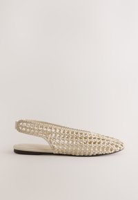 Chaussure plate beige tissée avec bride arrière, bout pointu fermé et semelle fine sur un fond clair uni.