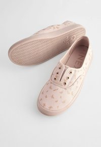 Scarpe da tela rosa con motivo di farfalle metalliche, dotate di due occhielli con accessori dorati, suole in gomma e grip strutturato.
