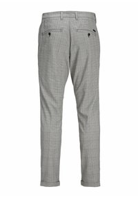 Pantalon de costume gris clair à carreaux avec passants de ceinture, deux poches arrière boutonnées et jambes fuselées avec revers.